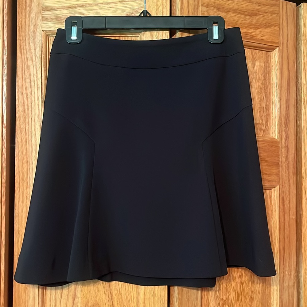 Black skirt. Above knee with some flare.